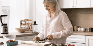 Woman preparing a home-cooked meal in her kitchen after working on a proactive health plan at Health for Life Naturopathic Clinic in Phoenix, AZ.