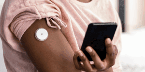 A woman monitoring her blood sugar with a continuous glucose monitor, provided by Health for Life Naturopathic Clinic in North Scottsdale, AZ