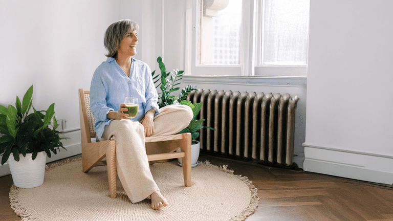 Relaxed older woman enjoying a green smoothie, representing healthy aging and wellness supported by peptide therapy in Scottsdale.