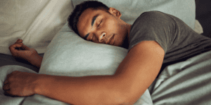 Person sleeping peacefully in bed, illustrating healthy sleep and rest.