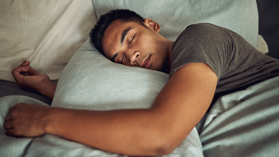 Person sleeping peacefully in bed, illustrating healthy sleep and rest.