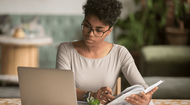 Woman reviewing her blood test results at a laptop while noting questions to bring to her doctor