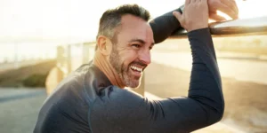 Active middle-aged man stretching outdoors, representing energy and healthy aging