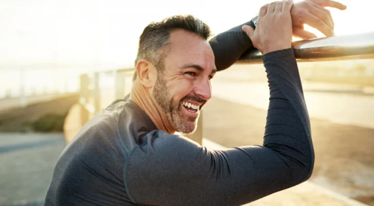 Active middle-aged man stretching outdoors, representing energy and healthy aging